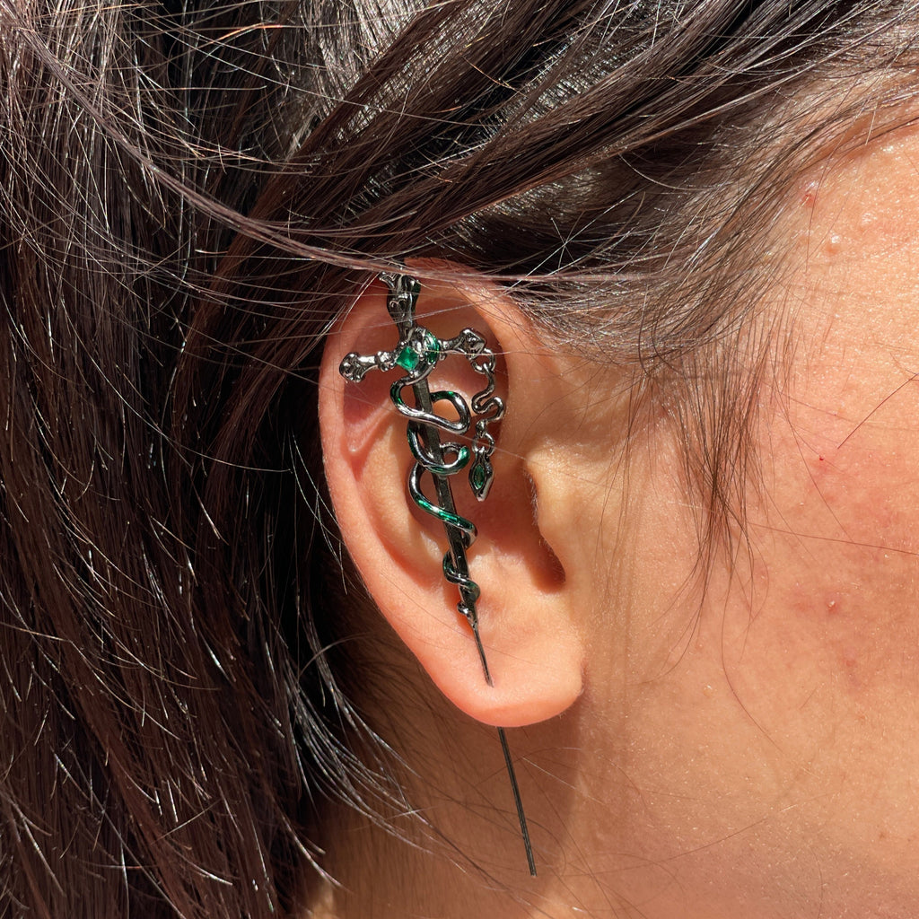 Close-up of an ear with a decorative earring and hair details.