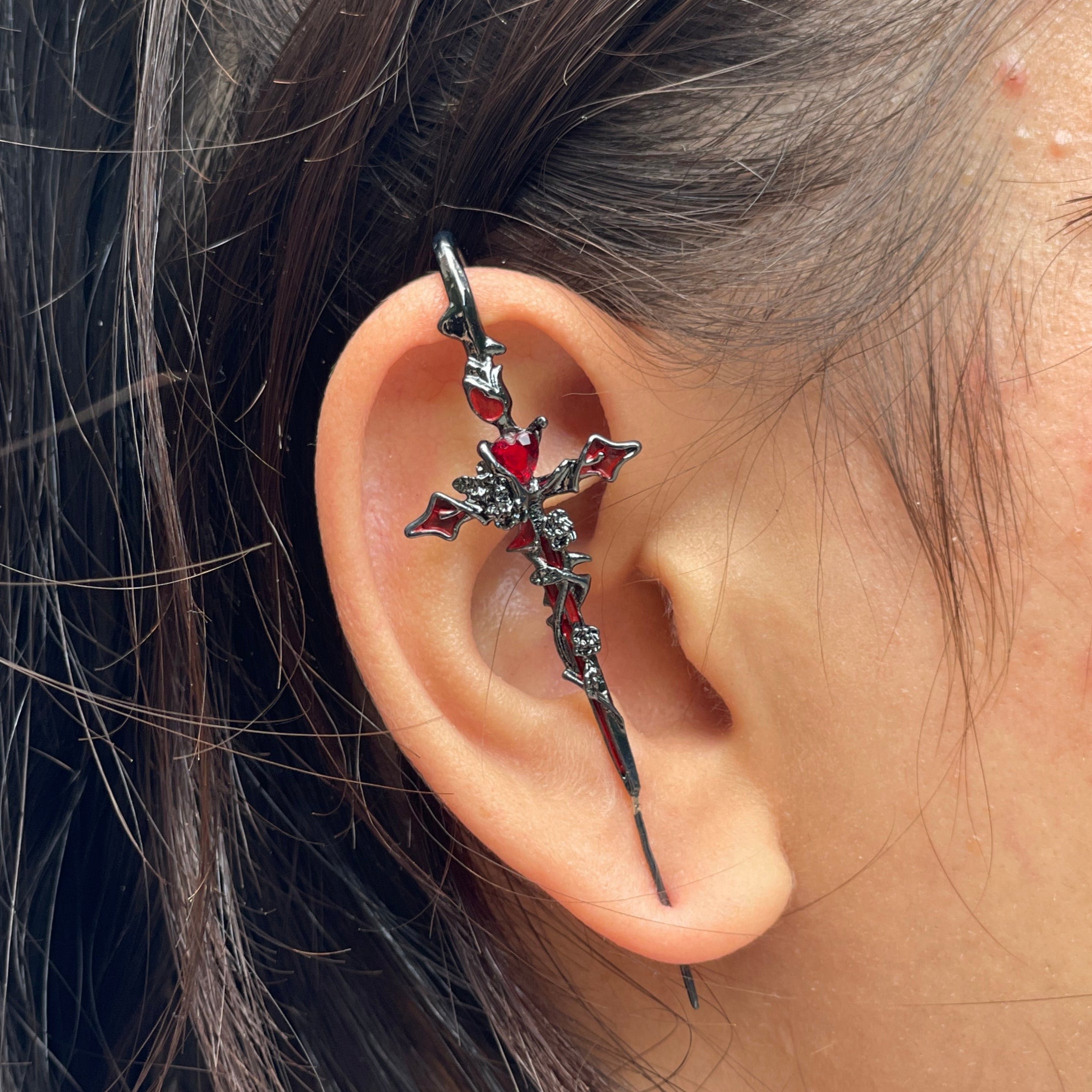 Close-up of an ear with a decorative earring, hair partially covering the face