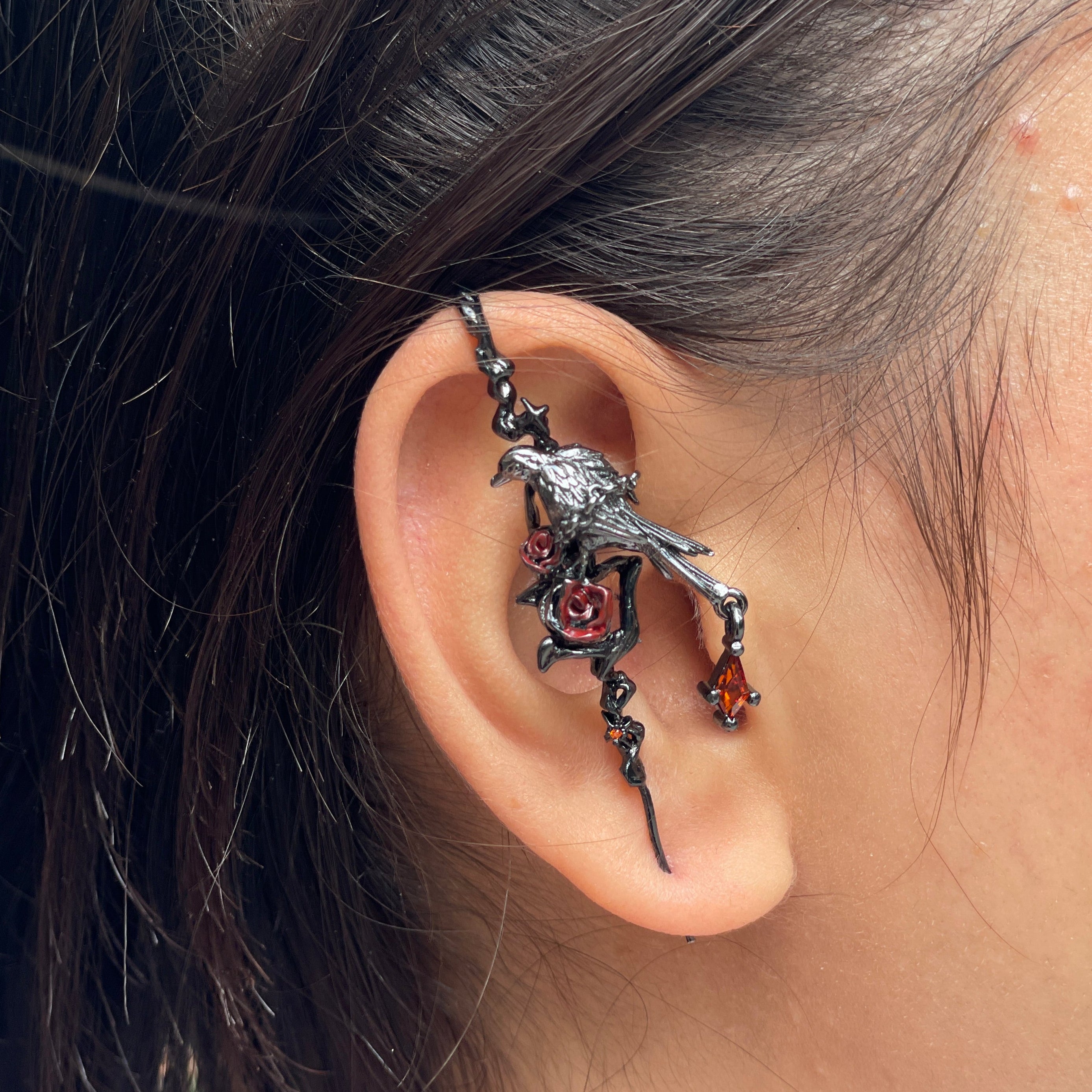 Close-up of an ear with a detailed dragon-shaped earring.
