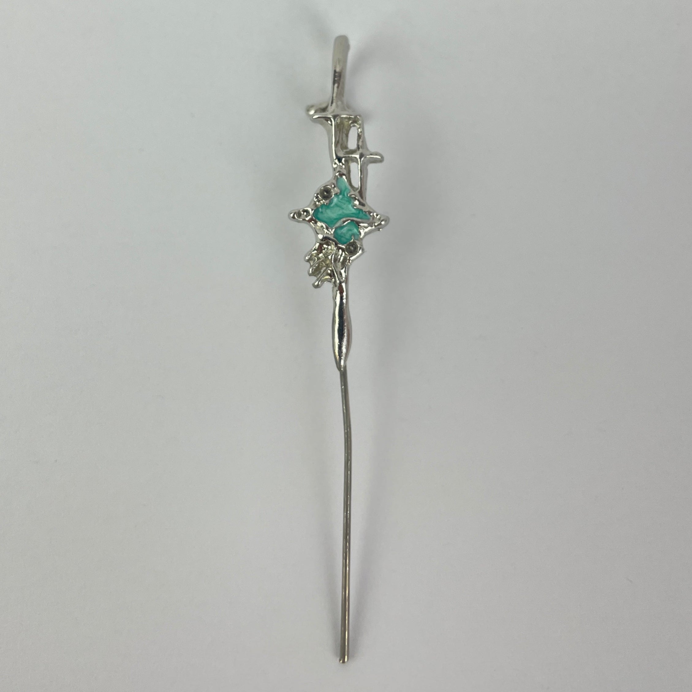 Silver bracelet with a central gemstone on a light gray background
