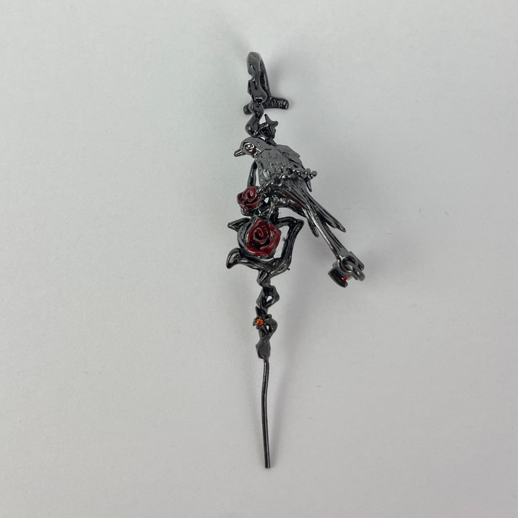 Decorative earring with intricate design on a light gray background