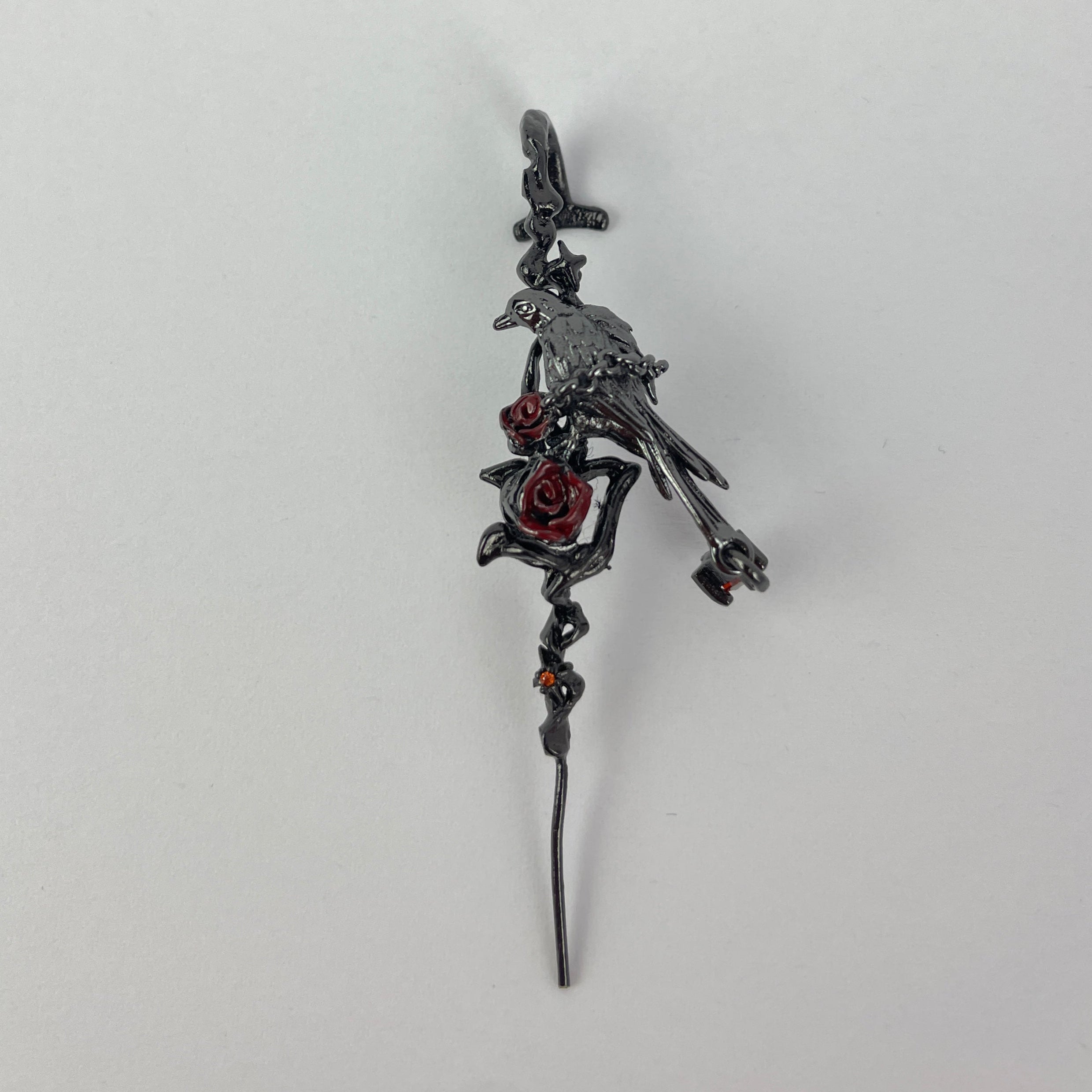 Decorative earring with intricate design on a light gray background