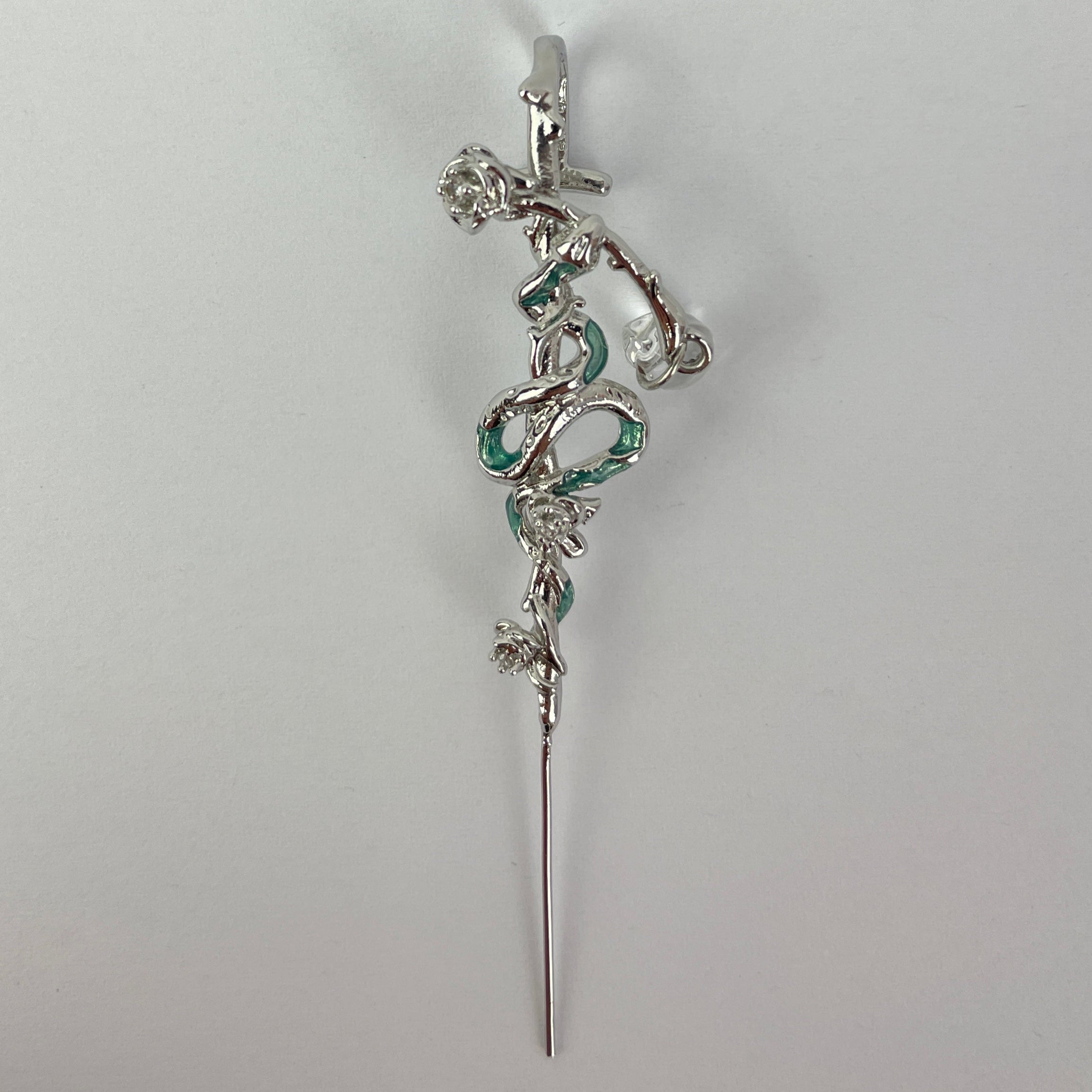 Silver hairpin with decorative elements on a light gray background