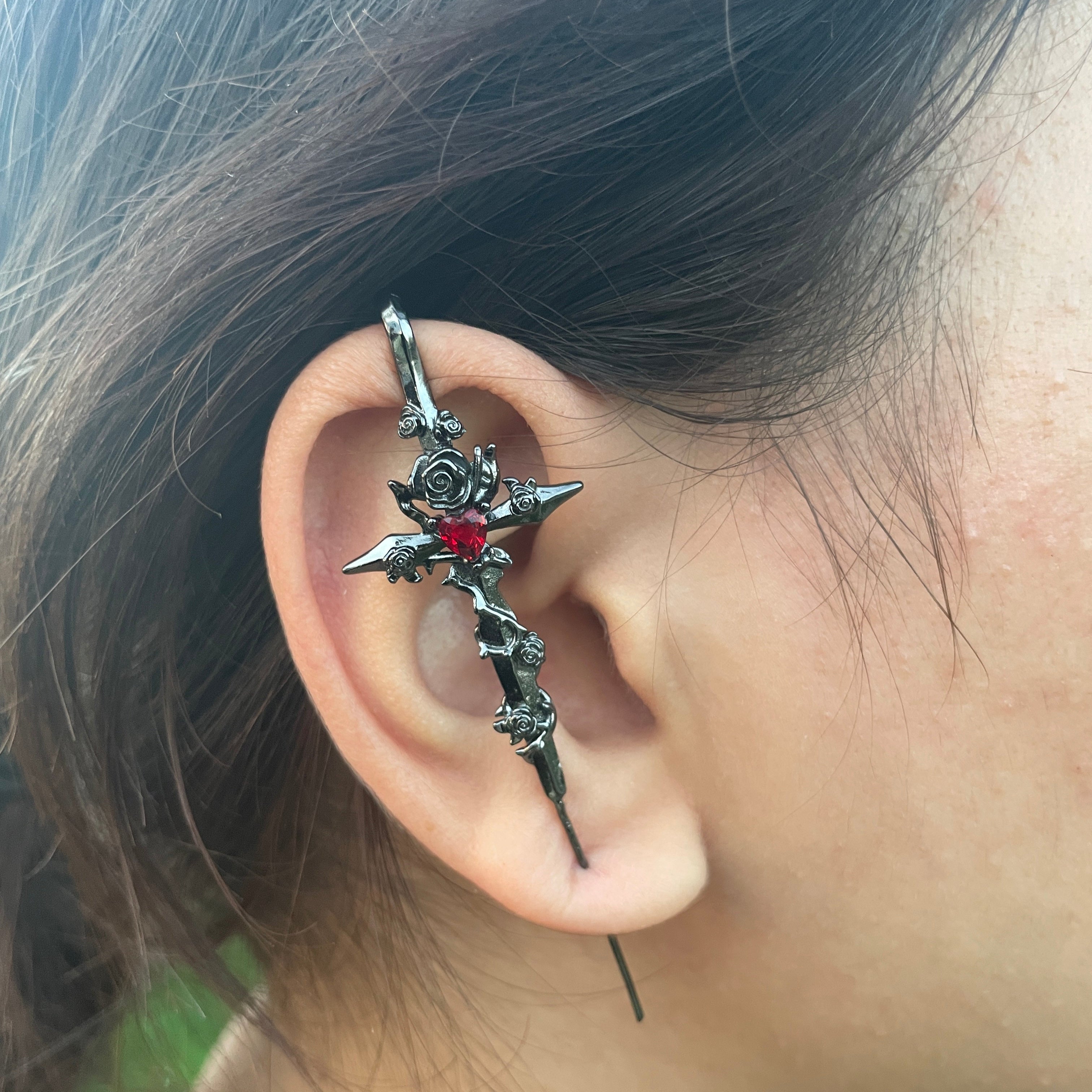Close-up of an ear with a decorative silver earring.