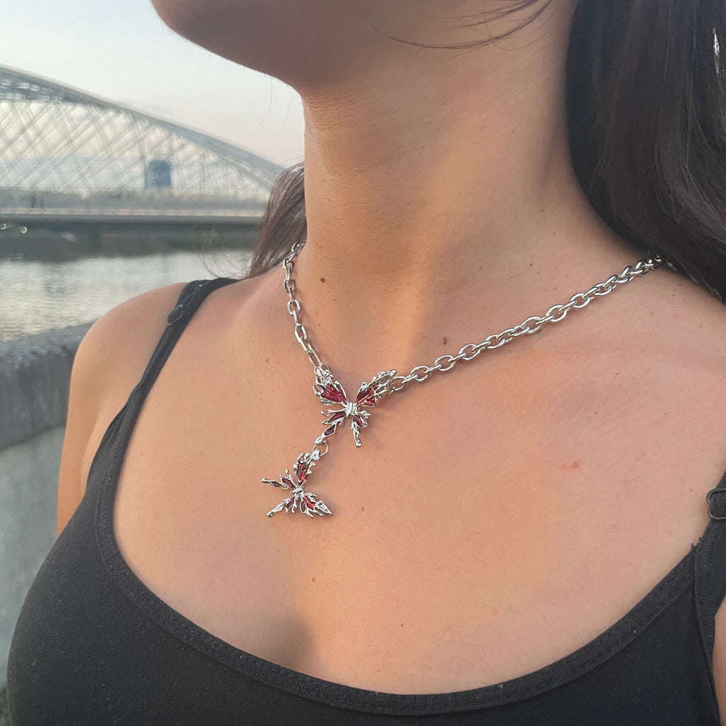Person wearing a black tank top with a star-shaped necklace.