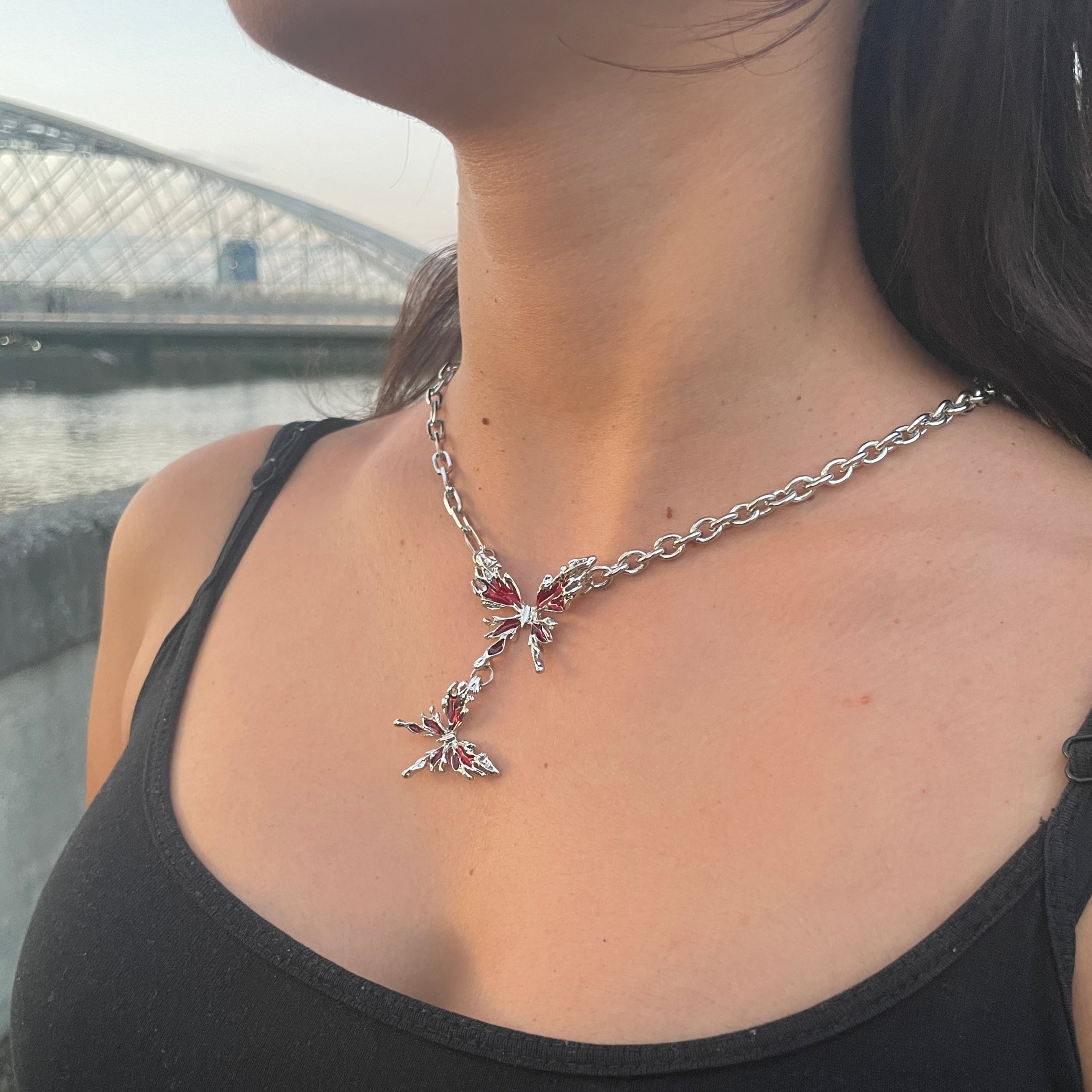 Person wearing a black tank top with a star-shaped necklace.