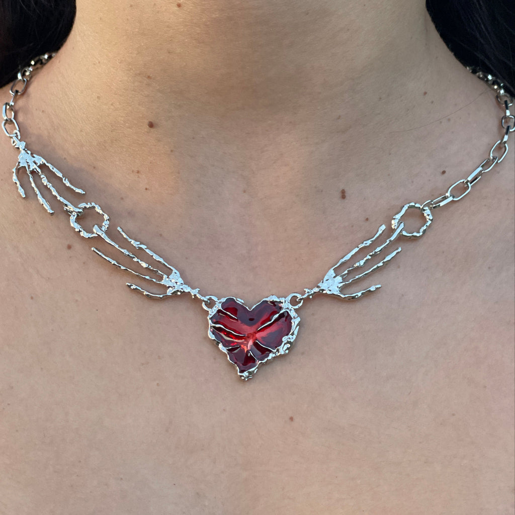 Necklace with a red gemstone on a person's neck