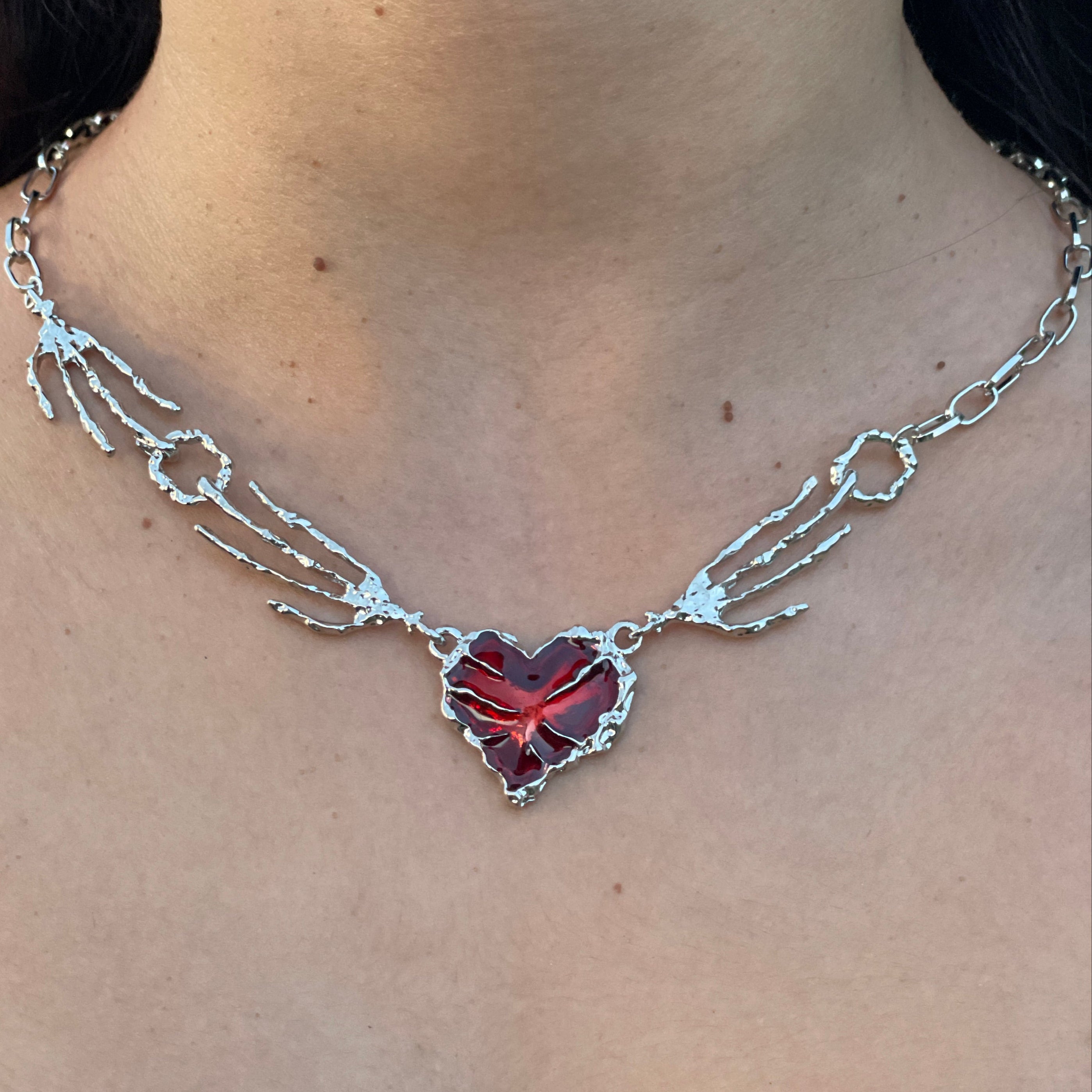 Necklace with a red gemstone on a person's neck