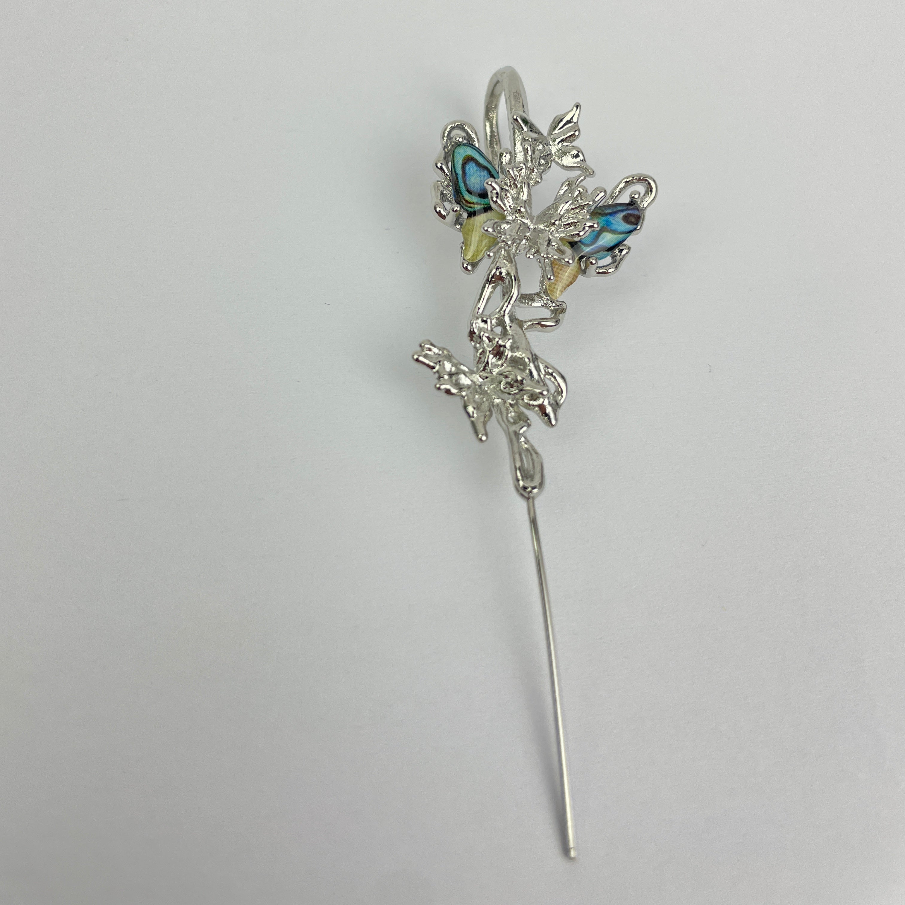 Silver hairpin with decorative elements on a white background
