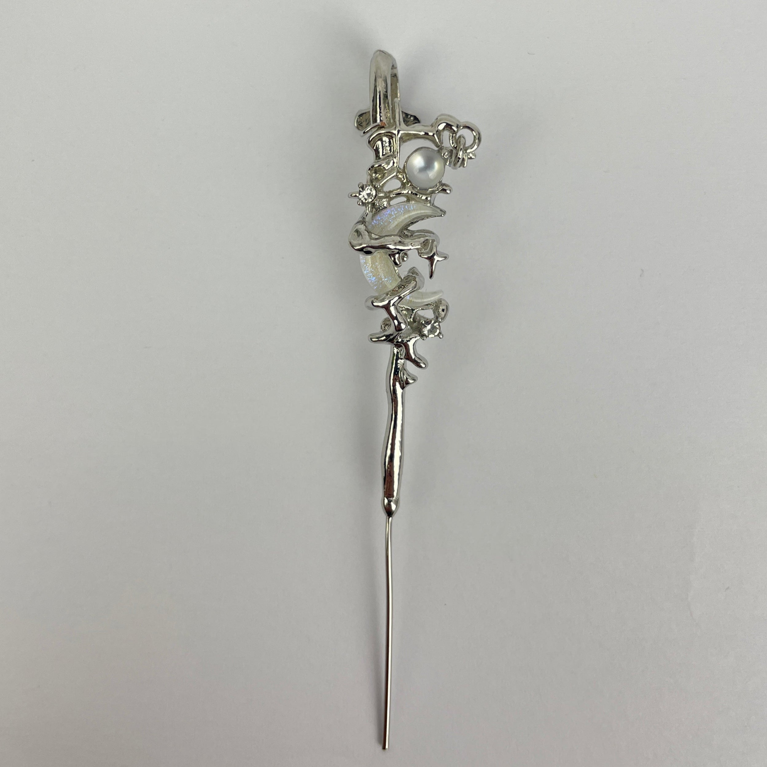 Silver hairpin with floral design on a light gray background