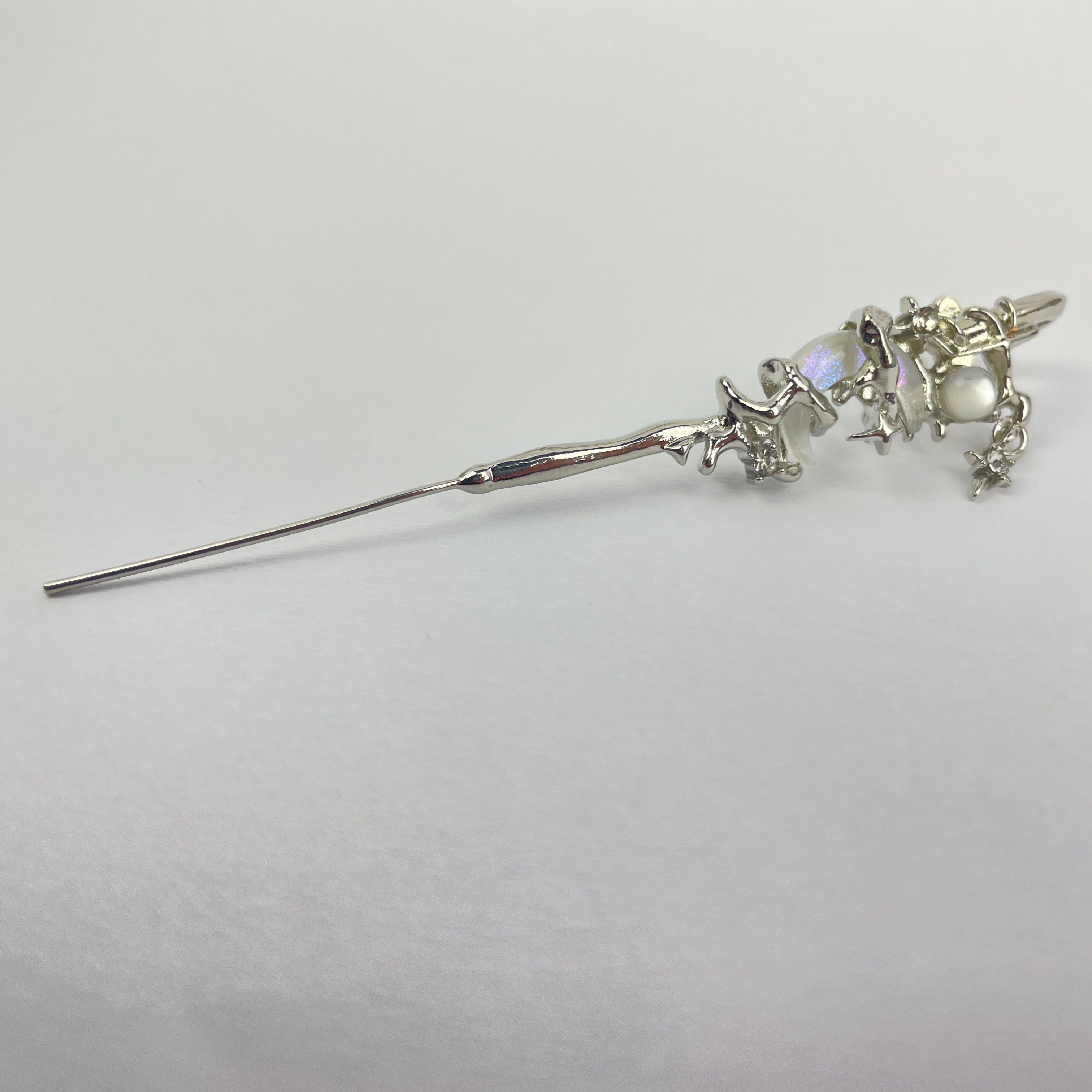 Silver hairpin with decorative elements on a white background