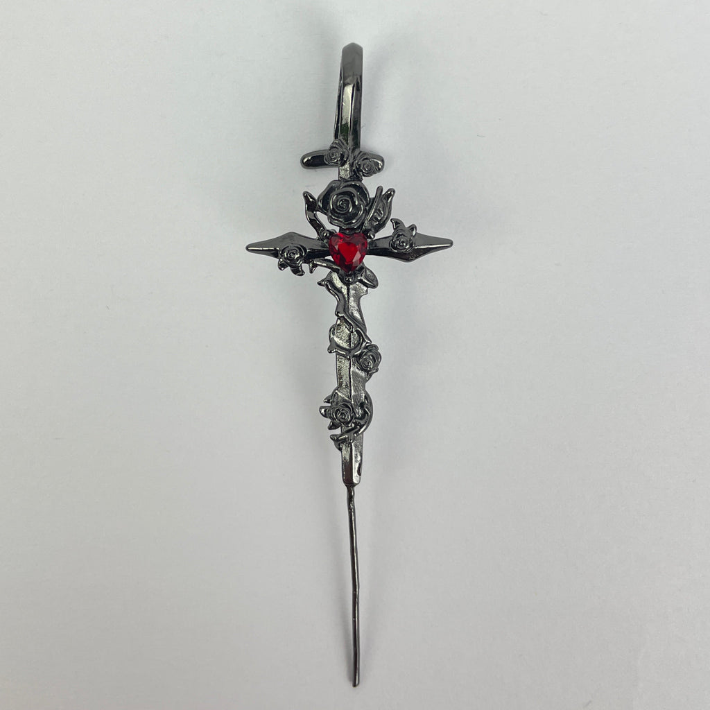 Decorative hairpin with floral design and red gemstone on a white background