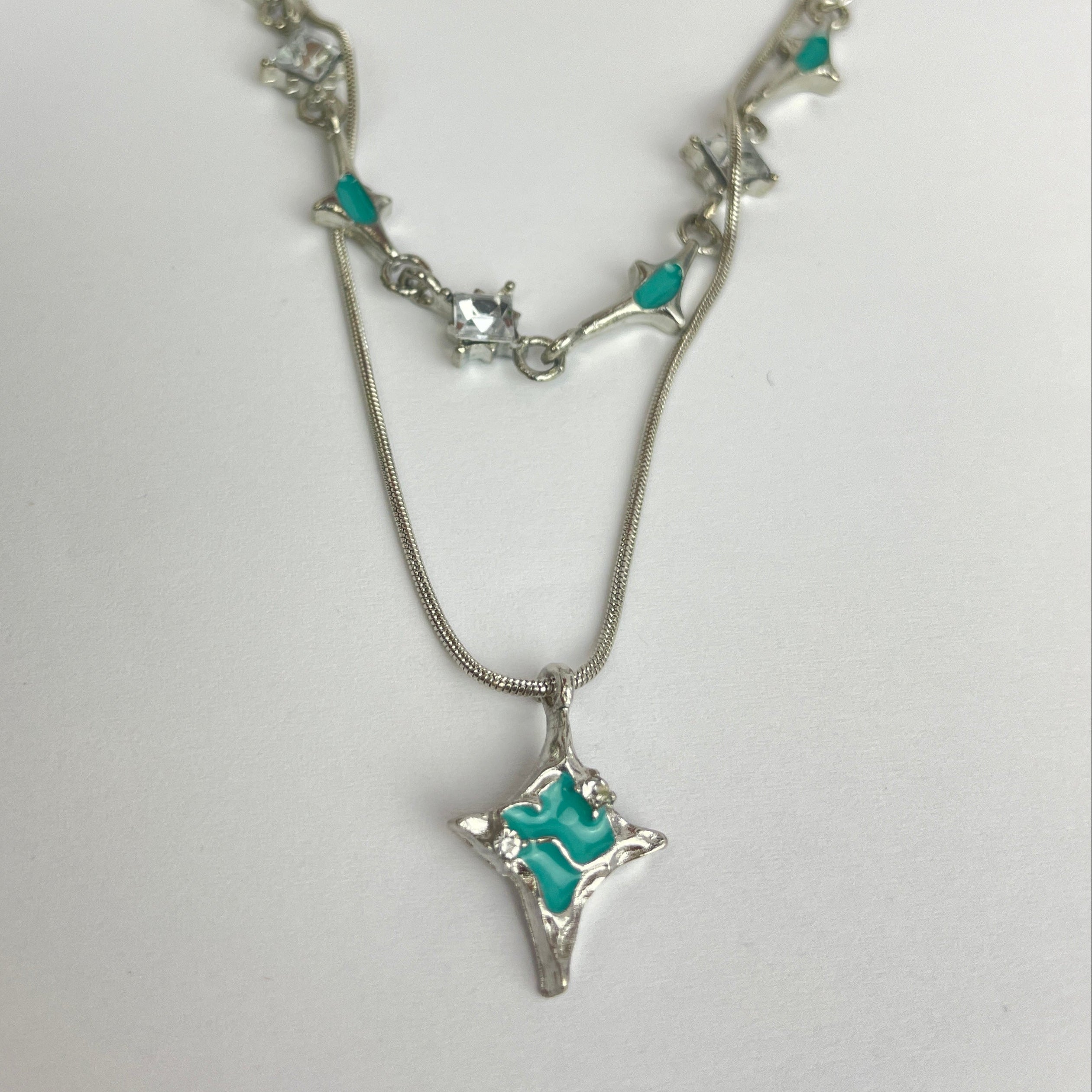Silver necklace with turquoise stones on a white background