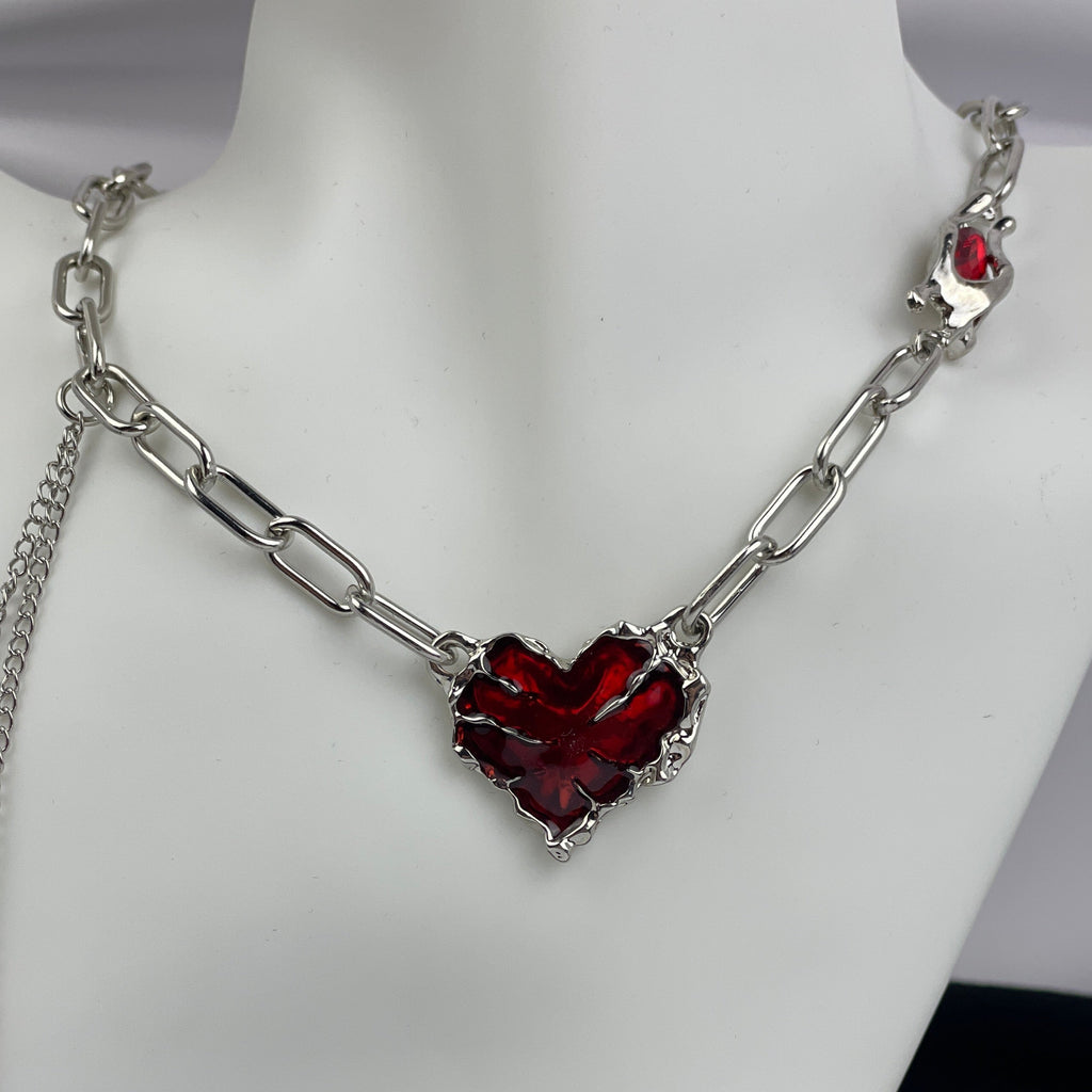 Necklace with a red heart-shaped pendant on a mannequin.