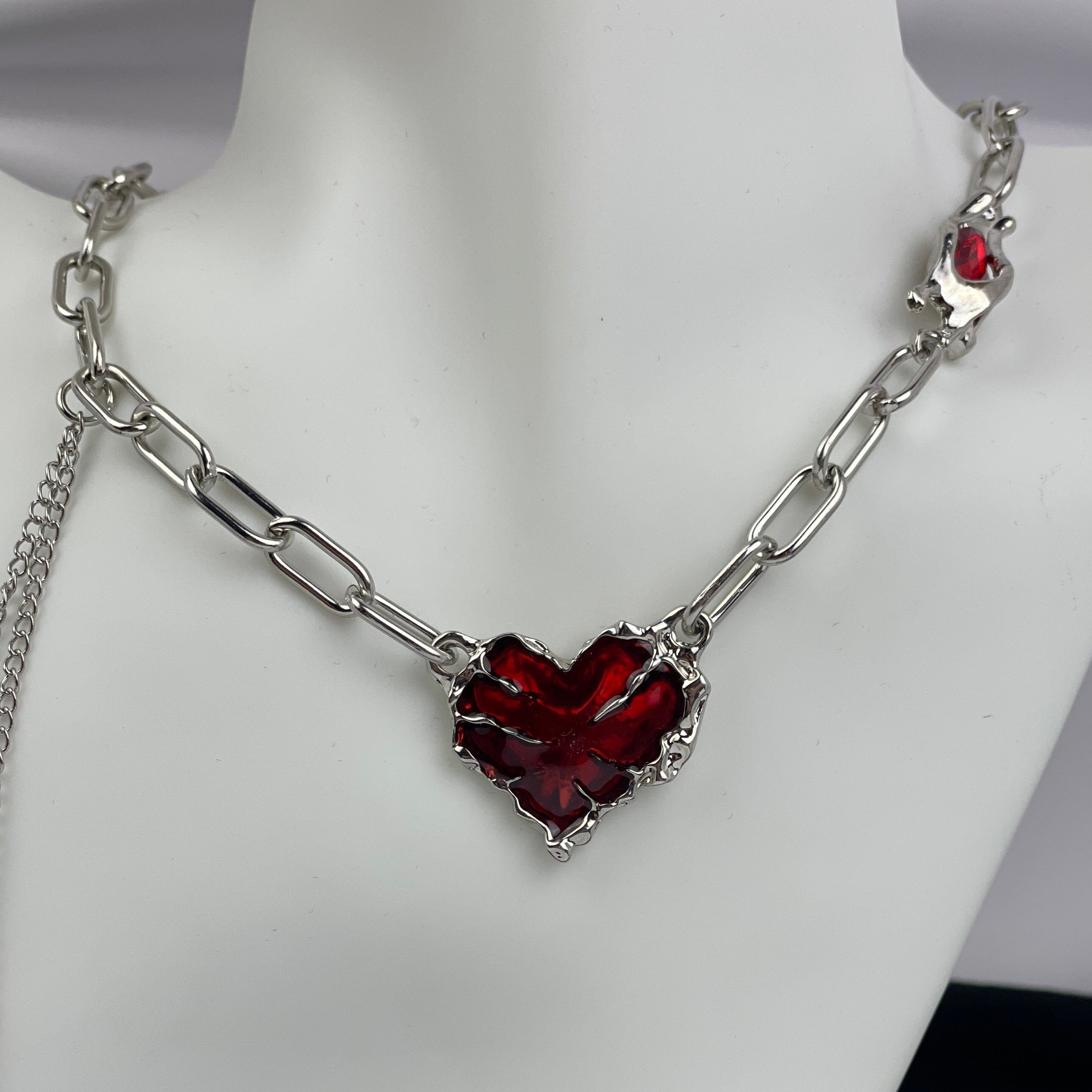 Necklace with a red heart-shaped pendant on a mannequin.