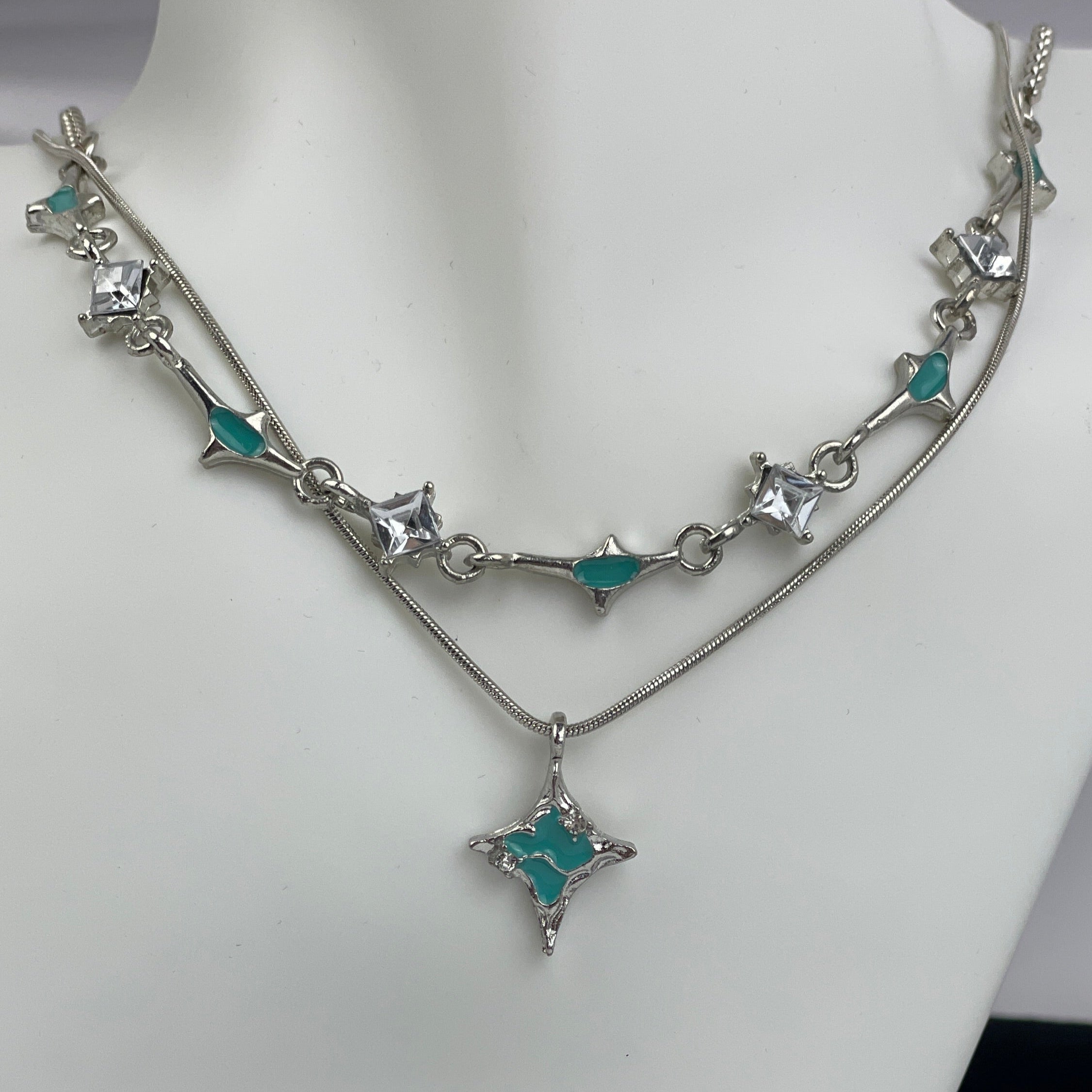 Necklace with star-shaped turquoise pendants on a mannequin bust.